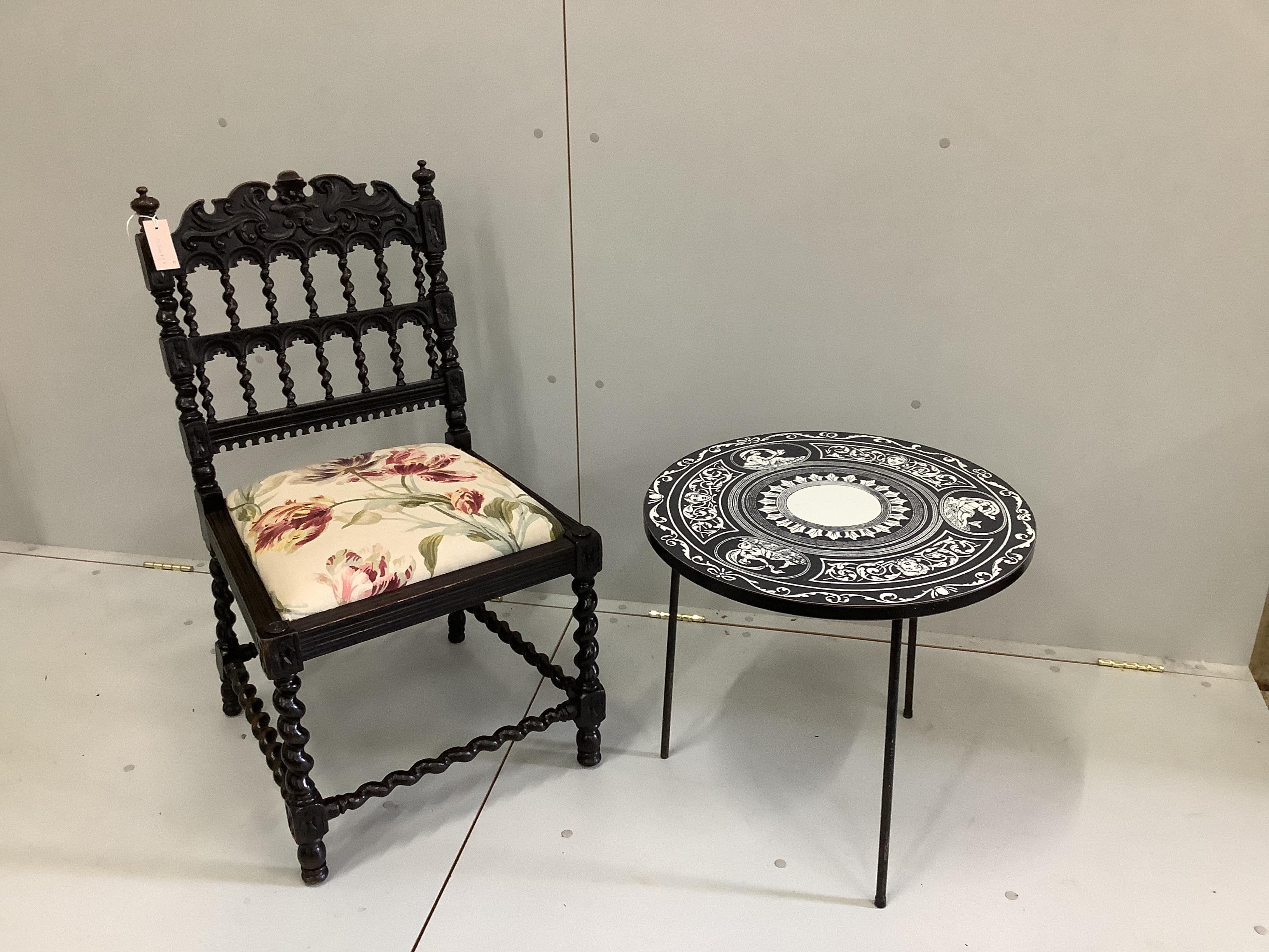 A Fornasetti style occasional table, diameter 52cm, height 48cm, together with a late 19th century Flemish carved side chair